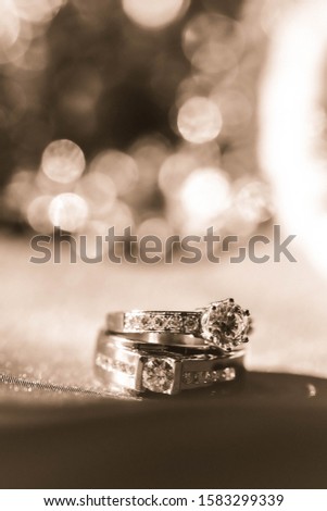 wedding rings on bokeh background, sepia picture style, diamond rings.