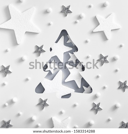 Christmas minimal concept - monochrome Christmas tree shape with white and silver star. Square composition, flat lay, view from above. Holiday magic pattern