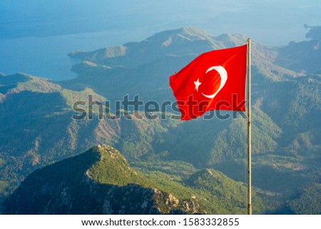 Turkish flag on the background of the mountains in Kemer, in the background the sea, sunny day, horizontal frame