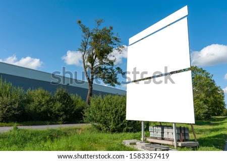 Blank white billboards for advertisement near factory/warehouse building