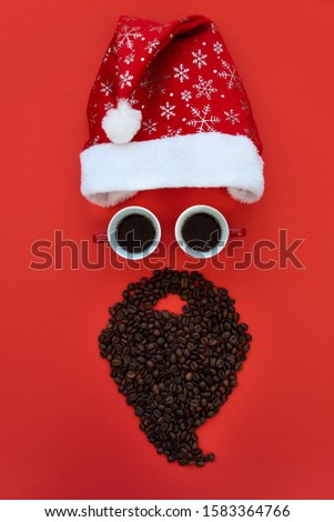 Santa Claus face made of coffee cups and coffee beans with hat on red background. Morning drink. Christmas or New Year celebration concept. Copy space. Top view