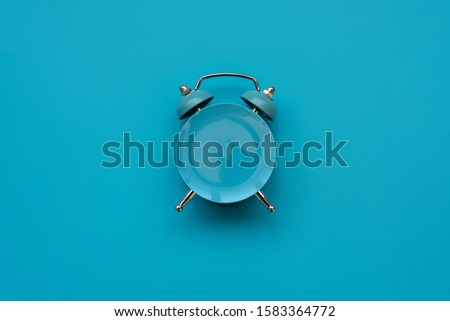 Time to eat. Empty plate as clock on blue background. Mock-up. Top view. Flat lay. Weight loss and diet concept Royalty-Free Stock Photo #1583364772
