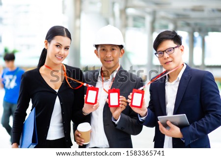 Engineering and architecture concept. Team of professional engineers working working on site and show the  Company employee red Card