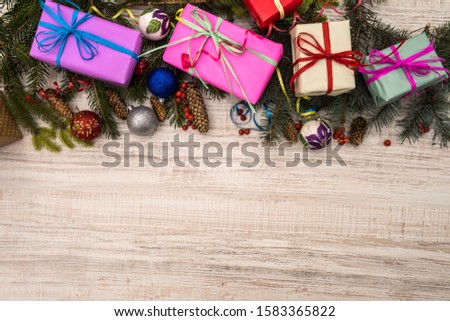 Christmas decorations with fir branches on wooden table. Gift boxes with ribbons. Presents concept