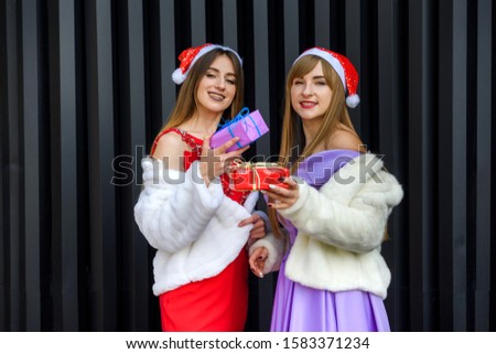Close-up photo of happy brunette woman giving gift box to her friend on new year celebration