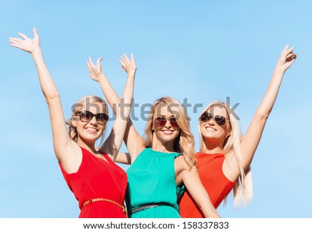 holidays and tourism, friends, hen party, blonde girls concept - three beautiful women waving hands over sky background