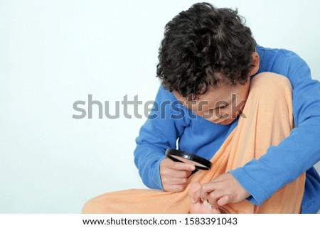 boy with magnifying glass ready to explore on white background stock photo