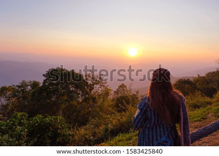 A relaxing traveler is happy with green natural forest in the morning sunrise. 
