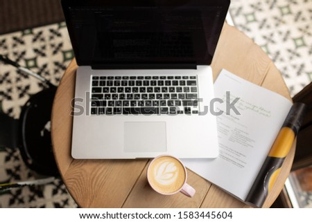 Work in a coffee shop with a laptop.Work over a cup of coffee.A laptop with glasses, a notebook and a magazine. Computer on the table.The working process.Rest for the soul.International day of coffee