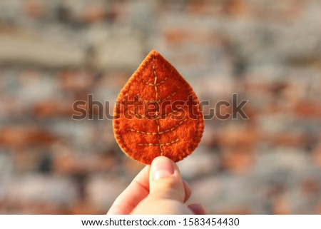 Orange leaf in a hand. Handmade leaves