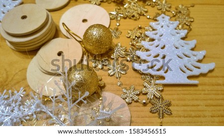 Materials and products for the manufacture of handmade Christmas decorations: white spruce tree, golden shiny balls and snowflakes, wooden round blanks with holes. Xmas ornaments. Happy New Year.
