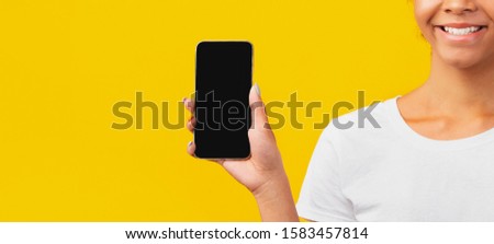 Cropped Image Of African American Woman Holding Mobile Phone With Blank Black Screen. Panorama, copy space