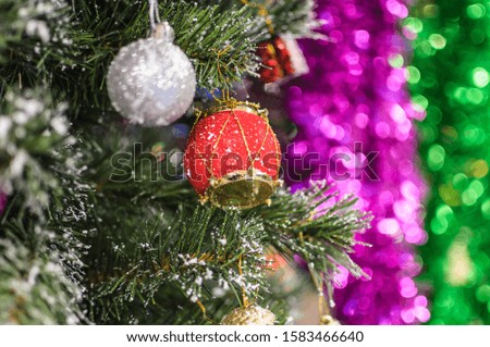 Colorful Christmas decoration close up details with pine covered with snow and soft focus background