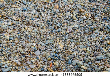 Background wallpaper of small stones and twigs on a Greek beach
