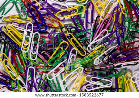 Colored paper clips. Metal office clips attach, on a light background. Stationery fix tool for page, card. The equipment for documentation.