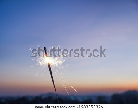A sparkler of celebretion on sunset background. 