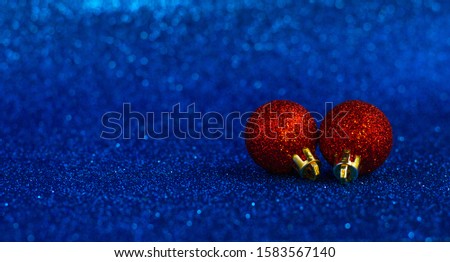 Christmas red ball on a blurry blue background. Beautiful bokeh. Background made in trendy classic blue color of the year 2020. Christmas, winter, New Year concept. Copy space.
