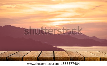 Empty display wooden board shelf counter with copy space for advertising backdrop and background with orange sunset island sky.