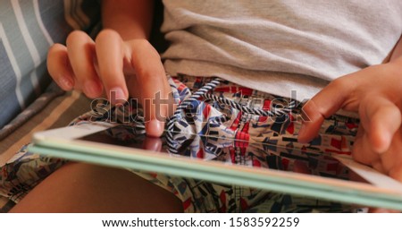 
Child hands touching tablet screen