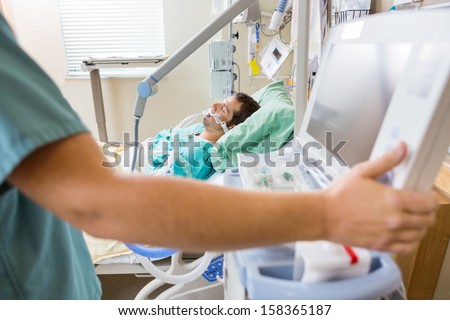 Cropped image of nurse pressing monitor's button with male patient lying on bed in hospital Royalty-Free Stock Photo #158365187