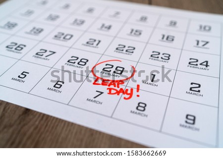 Calendar with marking in red ink of leap day: 29 february. With handwritten text of leap day. Close up with small depth of field. Royalty-Free Stock Photo #1583662669