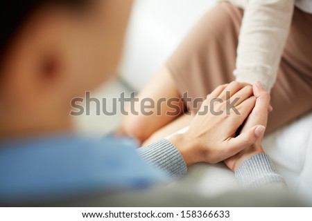 Close-up of psychiatrist keeping her hands together while listening to her patient