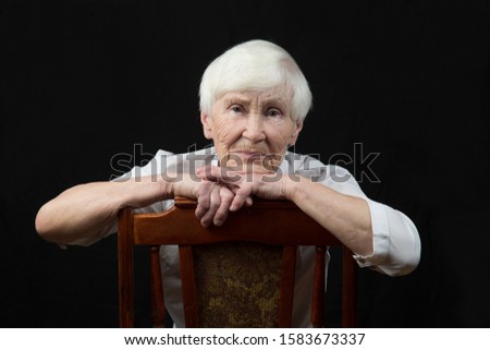 Portrait of an elderly woman, blonde on a black background.