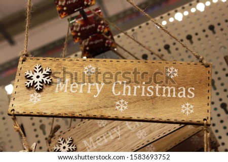 Merry christmas inscription in white on a wooden brown Board with white snowflakes