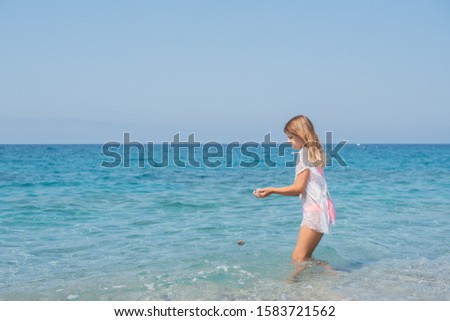 teen girl in swimsuit stands near the sea, the concept of travel, summer, vacation, recreation and childhood