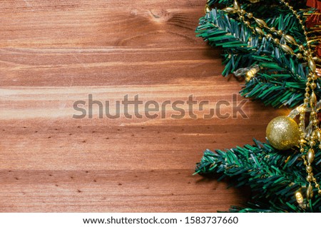 Christmas toys, decorations, cones, a garland and fir branches are laid out on the edge of a dark wood background. Copyspace in the center. Christmas card concept. Top view, close up, flat top.