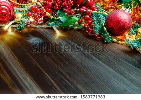 Composition of Christmas toys at the top on a dark wood background. Copy space in the center. New Year holidays and Christmas.
