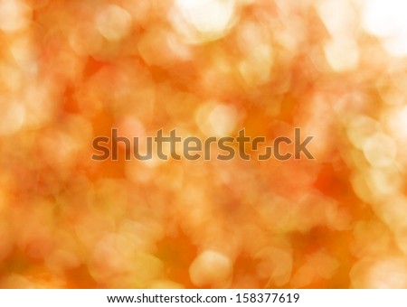 Autumn gold abstract background, blurred sun light - bokeh. Orange, brown and yellow dots.