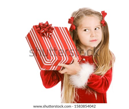 Cute, young girl in Christmas holiday dress, with gifts and props, isolated on white.
