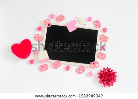 Valentine's frame composition background, pink chocolate, candy, black chalkboard on white wooden table texture, copy space for card or sale promotion for online business banner design, flat lay