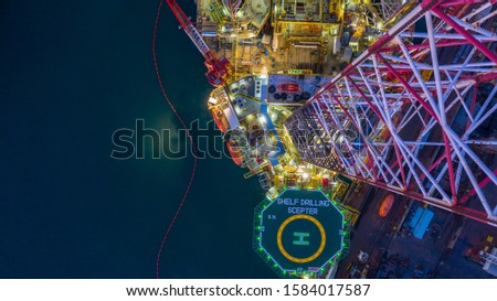Aerial view offshore jack up rig  at night, Offshore oil rig drilling platform. Royalty-Free Stock Photo #1584017587