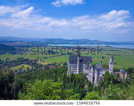 Neuschwanstein Castle from a higher angle, with plateau and lake in the background