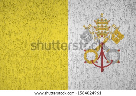 Vatican City State flag depicted in bright paint colors on old relief plastering wall. Textured banner on rough background