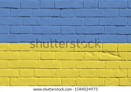 Ukraine flag depicted in paint colors on old brick wall. Textured banner on big brick wall masonry background