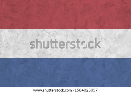 Netherlands flag depicted in bright paint colors on old relief plastering wall. Textured banner on rough background
