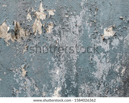The texture of cracked blue color paints on the old cement wall. 