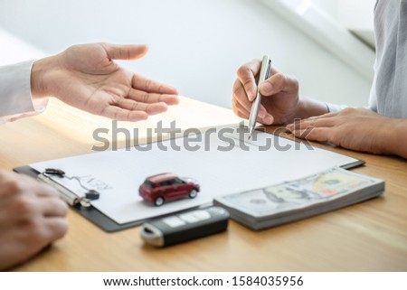 Car rental and Insurance concept, Young salesman presenting and pointing signature form to customer signing after decision sign agreement contract with approved good deal for rent or purchase.