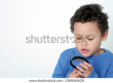 Little boy with magnifying glass ready to explore on white background stock photo