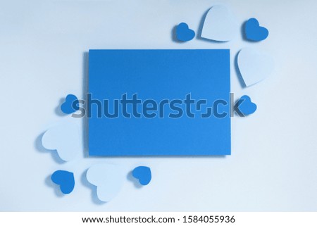 Valentine's day frame composition. Blue hearts, blank sheet of paper on pastel background. Top view, flat lay, copy space. Template design invitation card, mock up. Trendy color of the year 2020..