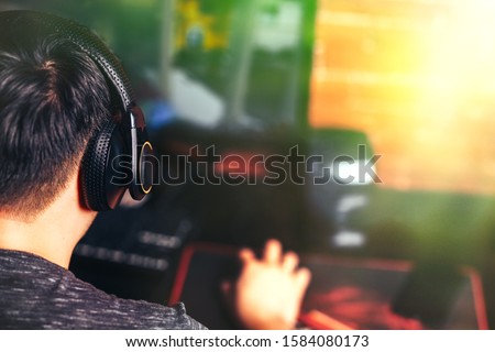 Gamer playing computer game in headphones, proccess. dark atmosphere photo.