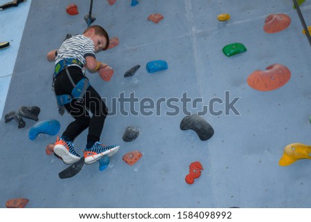Toddler Training Climbing On Indoor Climbing Wall. The concept of a healthy and active childhood, a healthy, sports child.
