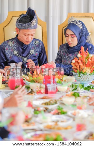 The bride couple  wearing Malay traditional  cloth  eats with their family or Makan Beradab  in wedding ceremony . Happy & Family Concept