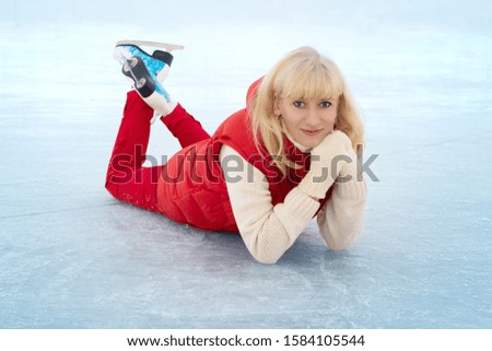 A woman on the rink is skating. New Years Eve. Fairy lights. Ice and snow mood concept. Winter sport. 