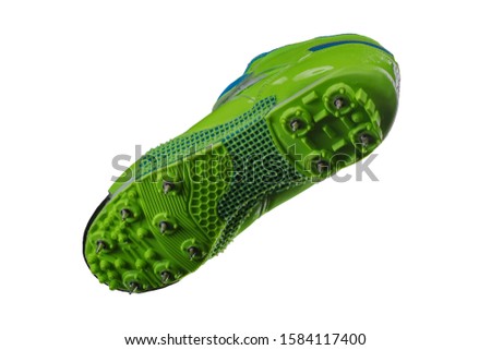 Green sole with spiked sneakers on a white background. Sport shoes.