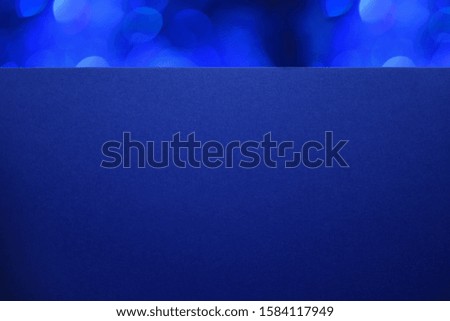 Closeup textured blue paper with Christmas blue bokeh. Macro. 