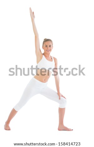 Toned smiling blonde doing yoga exercise on white background
